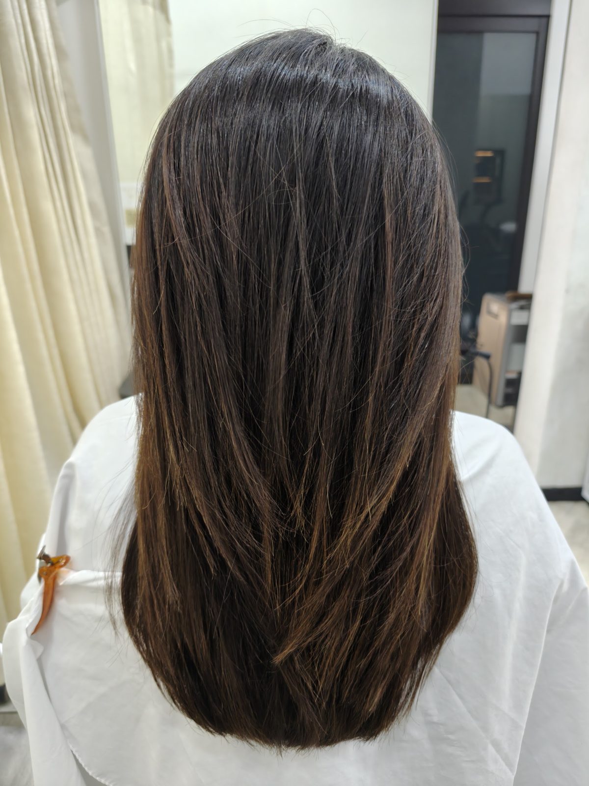 Long dark hair after a treatment, photographed from behind