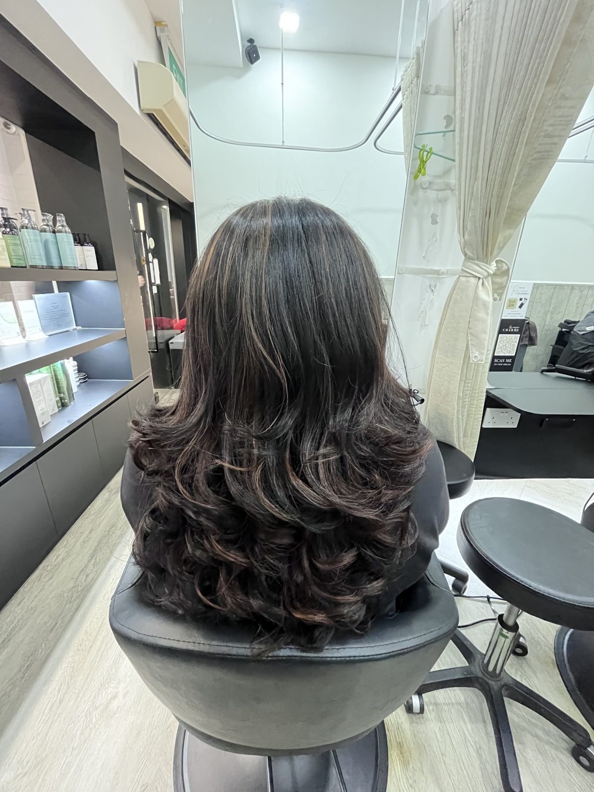 Dark hair with a curled finish in the styling chair